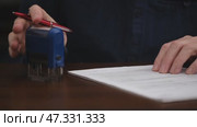 Close-up male hands signing an official document and putting seal. businessman signs an agreement or contract while sitting at his desk. concept business document management. front view. Стоковое видео, видеограф ЛУНИНА ВЕРОНИКА / Фотобанк Лори