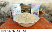 The ratio of Venezuelan money to a bowl of rice. Стоковое фото, фотограф Mikhail Davidovich / Фотобанк Лори