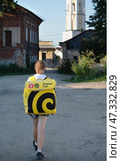 Tula, Russia. 24 July 2024. Food delivery courier, the inscription on the rucksack - Yandex food. Yandex courier A girl delivering food with a thermal backpack. Редакционное фото, фотограф Оксана Медведева / Фотобанк Лори
