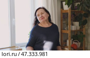 Senior woman dance at home. Elderly lady listening song and moving. Old female brunette feels calmly, relish carefree retired life looks happy. Vitality, wellness. Grandmother dancing alone indoors. Редакционное видео, видеограф Марина Демидюк / Фотобанк Лори