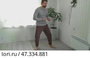 Handsome bearded man dance, have fun at home listens song, moves to music, feels overjoyed, celebrate good news, relish carefree life looks happy. Young adult male twirls, grooves. Brutal man dancer. Стоковое видео, видеограф Марина Демидюк / Фотобанк Лори