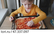 6 years old boy cooking pizza in the kitchen. Child rolling up the dough, adding cheese, tomatoes and smear sauce the base. Preschool kid making homemade pizza. Cooking class, culinary. Little baker. Стоковое видео, видеограф Марина Демидюк / Фотобанк Лори