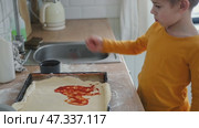 6 years old boy cooking pizza in the kitchen. Child rolling up the dough, adding cheese, tomatoes and smear sauce the base. Preschool kid making homemade pizza. Cooking class, culinary. Little baker. Стоковое видео, видеограф Марина Демидюк / Фотобанк Лори