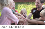 A friendly family joins their hands as a sign of joint success. Стоковое фото, фотограф Mikhail Davidovich / Фотобанк Лори