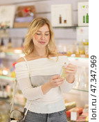 Woman customer chooses perfume in store, tests various fragrances, and selects right one. Стоковое фото, фотограф Яков Филимонов / Фотобанк Лори