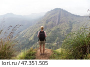 Active caucasian blonde woman enjoing fresh air and pristine nature while tracking among tea plantaitons near Ella, Sri Lanka. Bacpecking outdoors tourist adventure. Стоковое фото, фотограф Matej Kastelic / Фотобанк Лори