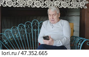 Portrait of senior man using mobile phone, holding device, texting, surfing internet. Old male looking at web camera, talking online. Elderly person chatting. Modern technologies and older generation. Стоковое видео, видеограф Марина Демидюк / Фотобанк Лори