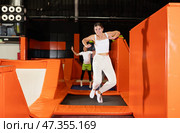 Excited young girl jumping at indoor trampoline center. Стоковое фото, фотограф Яков Филимонов / Фотобанк Лори