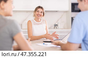 Woman manager tells clients about specifics of design of microloan, about benefits and advantages. Стоковое фото, фотограф Яков Филимонов / Фотобанк Лори