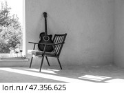 Guitar. Guitar chords. Acoustic guitar. Music. Musical background. An image of an acoustic guitar in a room with a retro armchair. Hard light. Shadows. Стоковое фото, фотограф Photojuli / Фотобанк Лори