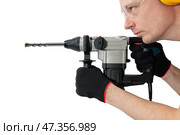 Professional worker with an impact drill in his hands on an isolated white background. Tool for drilling concrete and brick. Construction works. Стоковое фото, фотограф Дмитрий Кобзев / Фотобанк Лори