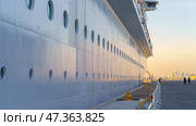 Doha, Qatar - Jan 14 2024, Panoramic view of the side of the moored MSC Virtuosa cruise ship and the dock, in the port of Doha, at evening, Doha, Qatar. Редакционное фото, фотограф Сергей Богомяко / Фотобанк Лори