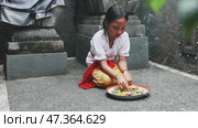 The Offering Ceremony by a Young Balinese Girl in Bali reflects cultural heritage and beliefs. Стоковое видео, видеограф Евдокимов Максим / Фотобанк Лори