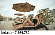 The girl lies on a sunbed on the roof of the hotel. Стоковое видео, видеограф Mikhail Davidovich / Фотобанк Лори