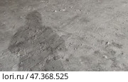 Shadow of a man in the snow. On the white, almost flat surface of the snow, the shadow of a standing man is visible from the light of a street lamp. The man is wearing a long jacket with a hood and is looking at his shadow. Стоковое видео, видеограф Andrew_Swarga / Фотобанк Лори
