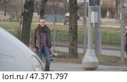 Мужчина с цветами стоит на перекрёстке. Редакционное видео, видеограф Семён Прудий / Фотобанк Лори