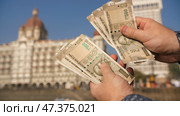 A man considers Indian 500 rupees on Mumbai street. Hands close up. Стоковое фото, фотограф Mikhail Davidovich / Фотобанк Лори