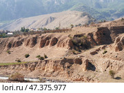 Slipped ground masses (landslide) with residential houses and gardens on the bank of a mountain river. The river bank is eroded and destroyed. Стоковое фото, фотограф Роман Дзюбало / Фотобанк Лори
