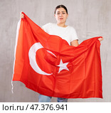Sad young woman holding Turkey flag against unicoloured background. Стоковое фото, фотограф Яков Филимонов / Фотобанк Лори