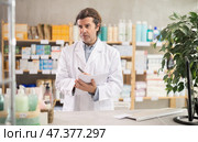 Man pharmacist makes restock, uses paper carrier of information. Стоковое фото, фотограф Яков Филимонов / Фотобанк Лори