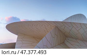 Doha, Qatar - Jan 06 2024, a close up view of part of facade of National Museum of Qatar, shaped like a desert rose, at evening with blue sky, Doha, Qatar. Редакционное фото, фотограф Сергей Богомяко / Фотобанк Лори