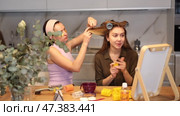 Adult woman curls hair of young woman. Стоковое видео, видеограф Яков Филимонов / Фотобанк Лори