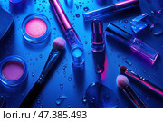 На синей поверхности представлена коллекция кисточек и флакончиков для макияжа. Стоковое AI-изображение, AI-художник Ярославский Максим / Фотобанк Лори