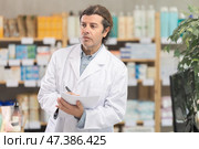 Man pharmacist makes restock, uses paper carrier of information. Стоковое фото, фотограф Яков Филимонов / Фотобанк Лори