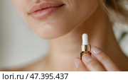 Close-up of a woman applying facial serum in a bright, serene setting to enhance her skincare routine and rejuvenate her complexion. Стоковое AI-изображение, AI-художник Сергей Толмачёв / Фотобанк Лори
