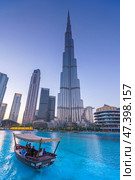Dubai, United Arab Emirates - Jan 19 2024, vertical view of the Burj Khalifa Tower from below, at evening, with a boat on foreground, Dubai, UAE. Редакционное фото, фотограф Сергей Богомяко / Фотобанк Лори