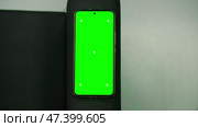 Mobile phone with green screen lies on the sofa. Mobile phone mockup. Social media and market advertising concept. Smartphone with chromakey. Close-up. Place for your text, logo, advertising. Banner. Стоковое видео, видеограф Евгений Демидюк / Фотобанк Лори