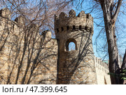 An old stone tower with battlements and bare trees. Baku. Стоковое фото, фотограф EugeneSergeev / Фотобанк Лори