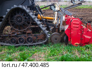 Close-up of a tracked tractor with a mounted cultivator working on agricultural land. Soil cultivation, agricultural technology. Стоковое фото, фотограф Коханова Наталья / Фотобанк Лори