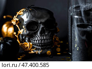 A mysterious black skull with golden roses and pumpkins for a Halloween or Day of the dead party on a black grunge background. Стоковое фото, фотограф Photojuli / Фотобанк Лори