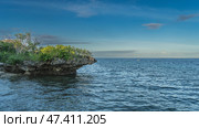 Tropical seascape. Blue ocean and azure sky with clouds. A coastal cliff overhangs the sea. Green vegetation on the rocks. Ripples on the water. Philippines. Cebu. Стоковое фото, фотограф Вера Ивановна Кубарева / Фотобанк Лори