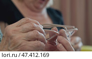 Elderly woman cleaning her glasses with cloth. Стоковое видео, видеограф Константин Шишкин / Фотобанк Лори