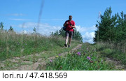 Exploring Nature a Hiker with backpack Strolling Through a Beautiful Field Beneath Vast Blue Sky. Tourist man traverses a scenic field, clear blue sky. Adventure and exploration concept. One person. Стоковое видео, видеограф Марина Демидюк / Фотобанк Лори