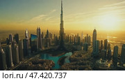 Majestic skyline of Dubai at sunset showcasing Burj Khalifa and modern architecture over shimmering waters. Стоковое AI-видео, аниматор Ekaterina Ismagilova / Фотобанк Лори
