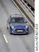 Blue mini cooper car driving on asphalt highway, aerial front view. Редакционное фото, фотограф Константин Григорьев / Фотобанк Лори