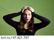 Teen Girl Expresses Surprise in Studio With Green Background and Emotional Pose. Стоковое фото, фотограф Aleksandr Golubev / Фотобанк Лори