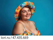 Happy woman in beach hat on blue background, chubby plus size model portrait. Стоковое AI-изображение, AI-художник Станислав Тарко / Фотобанк Лори