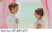 The bride and the bridegroom swear an oath to each other. Wedding ceremony at the beach of the Philippines. Стоковое видео, видеограф Mikhail Davidovich / Фотобанк Лори