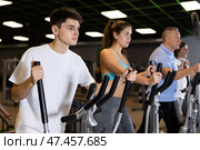 Race walking on elliptical trainers in modern gym. Стоковое фото, фотограф Яков Филимонов / Фотобанк Лори