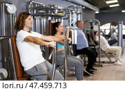 Sporty man doing chest press on execise machine in gym. Стоковое фото, фотограф Яков Филимонов / Фотобанк Лори