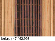 Dark and light bamboo mat in the form of a scroll lie on the burlap. Стоковое фото, фотограф Александр Собко / Фотобанк Лори