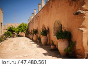 A sun-drenched walkway Arkadi Monastery, arched insets and large clay pots. Стоковое фото, фотограф Artem Fomin / Фотобанк Лори