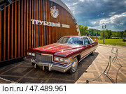 Красный ретро-автомобиль Кадиллак перед зданием 'Трубецкой Холл' на территории усадьбы Гребнево (2023 год). Редакционное фото, фотограф Владимир Шипикин / Фотобанк Лори