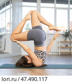 Young woman practicing vinyasa yoga in studio. Стоковое фото, фотограф Яков Филимонов / Фотобанк Лори