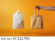A crumpled plastic bag dissolves into air, symbolizing environmental change. A hand holds a natural cotton tote, promoting sustainability and eco-conscious choices. Стоковое AI-изображение, AI-художник Nart / Фотобанк Лори