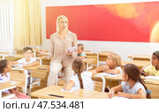 Female teacher working with tweenager pupils in classroom. Стоковое фото, фотограф Яков Филимонов / Фотобанк Лори